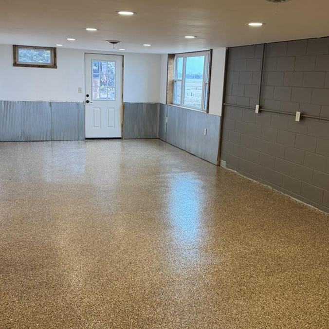 Residential basement with tan and black painted coating.